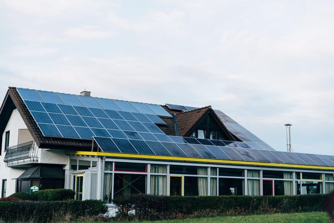 Wohnhaus mit angebautem Wintergarten, darüber eine durchgehende Modulfläche über die gesamte Dachlänge.